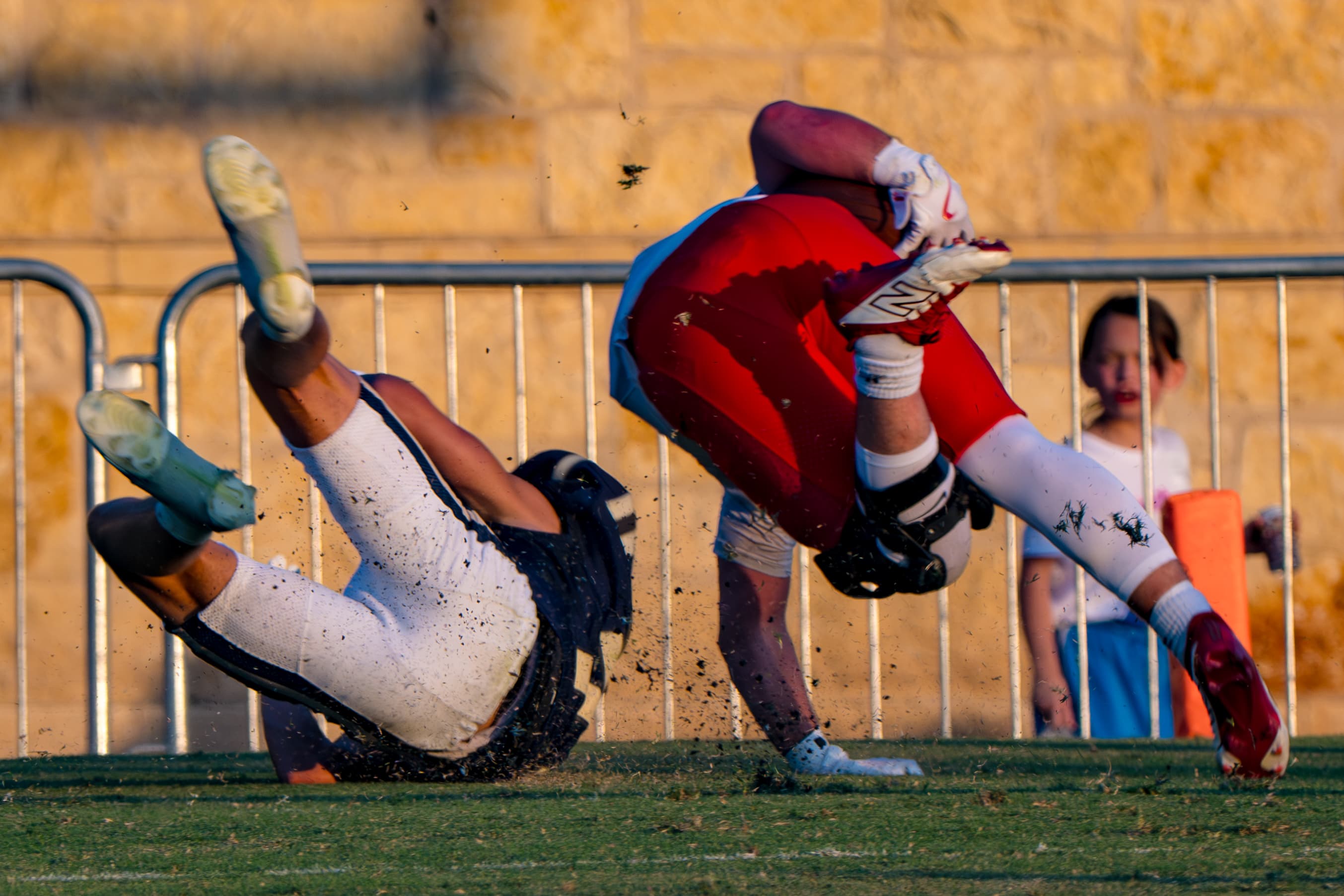 Full-speed collision between two athletes in golden afternoon light
