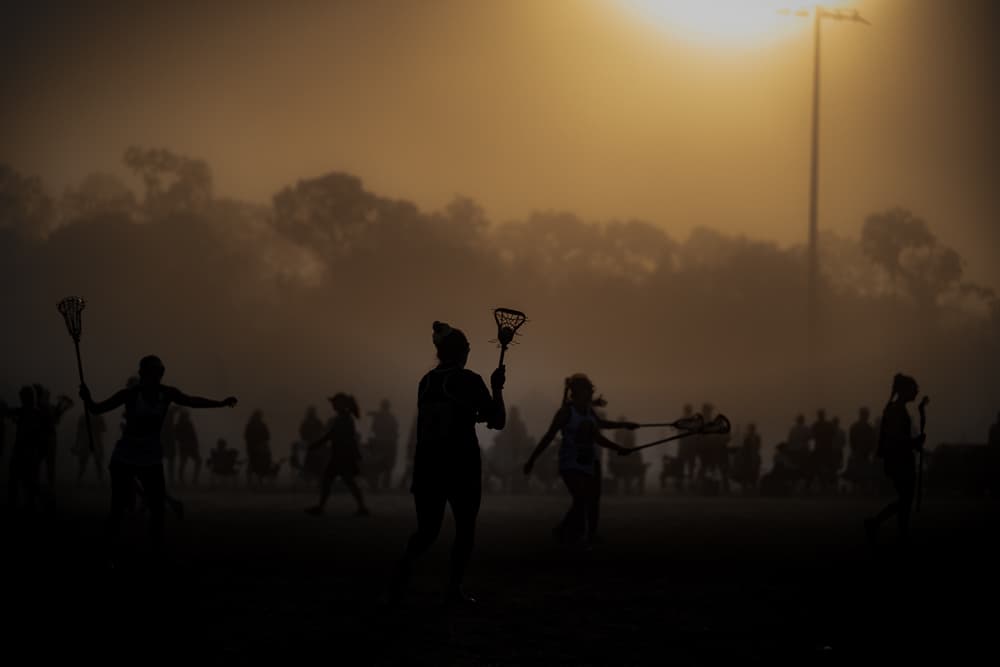 Athletes silhouetted against a golden morning fog